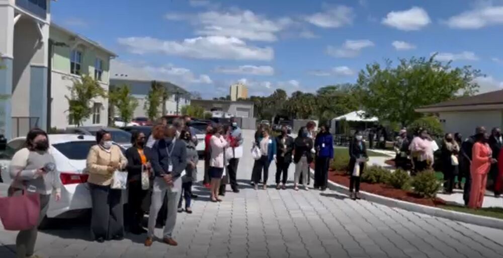 Group of people outside with masks at new property at ribbon cutting